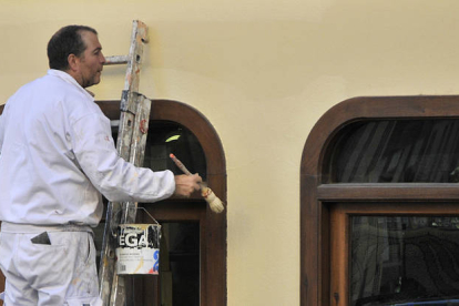 Un empleado realiza trabajos de pintura, en una imagen de archivo. / VALENTÍN GUISANDE-
