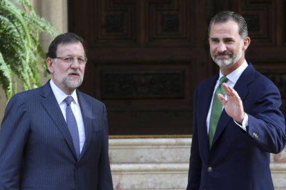 El rey Felipe VI saluda junto al presidente del Gobierno, Mariano Rajoy (i), hoy al Palacio de Marivent, en Palma de Mallorca, donde se han reunido en el único despacho que ambos celebran este verano en la residencia de verano de la familia real.-Foto: EFE