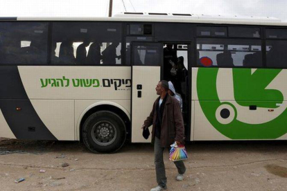 Obreros palestinos bajan de su autobús para cruzar a la franja de Gaza, a través del control militar de Eyal, cerca de Qalquilya, en marzo del 2013.-Foto: REUTERS / BAZ RATNER