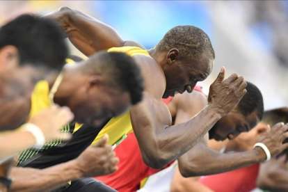 Usain Bolt toma la salida en las series de los 100 metros, su debut en los Juegos de Río.-AFP / FABRICE COFFRIN