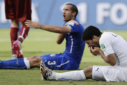 Momento en el que el delantero uruguayo agrede al defensa italiano, durante el partido correspondiente al Mundial de Brasil.-AP