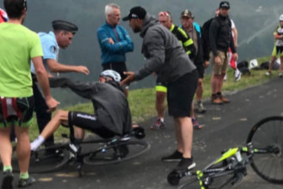 Froome, en el suelo tras ser derribado por un gendarme francés. /-ALBERT SECALL