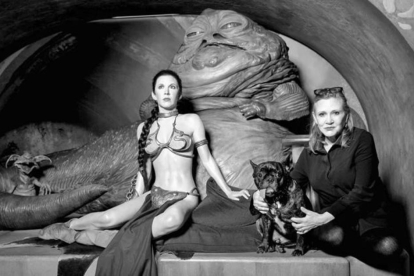 Carrie Fisher, junto a su perro Gary, el 31 de mayo del 2016 junto a la figura del museo de cera de Madame Tussaud, en Londres, que la representa con rehén de Jabba.-