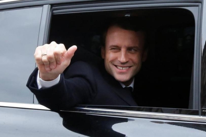Emmanuel Macron, saluda feliz desde el coches el día de la segunda vuelta de las presidenciales.-REUTERS