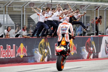 Los mecánicos de Marc Márquez reciben a su campeón encaramados al muro de Austin tras su última victoria.-