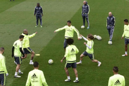 Zidane observa los movimientos de sus jugadores en el entrenamiento de este viernes en Valdebebas.-AFP / JAVIER SORIANO