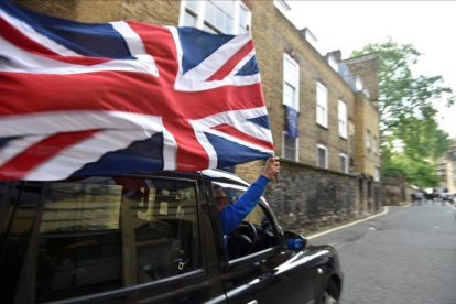 Un motorista con una bandera británica en el centro de Londres.-TOBY MELVILLE / REUTERS