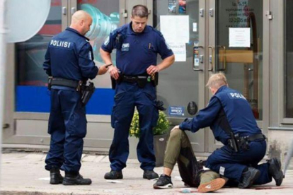 La policía atiende a uno de los heridos en Turku.-AFP / KIRSI KANERVA