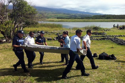 La Policía de las Islas Reunión traslada una de las piezas encontradas.-Foto: AFP