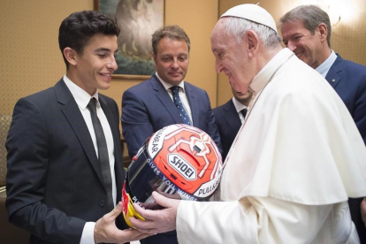 Marc Márquez le entrega uno de sus cascos al Papa Francisco en presencia de Emilio Alzamora-VATICAN MEDIA
