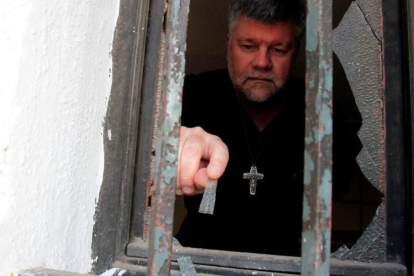 Un sacerdote evalúa los daños ocasionados en una de las iglesias atacadas durante la visita del Papa a Chile.-REUTERS