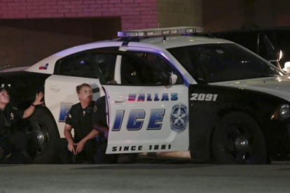 Varios policías, parapetados tras un coche patrulla, durante el tiroteo en Dallas.-Maria R. Olivas / AP