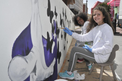 Lola Lisa y Julita Romera, ayer, pintado una de las siete obras que compondrán el mural homenaje a la mujer.-Valentín Guisande