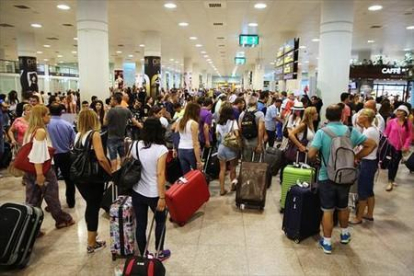 Decenas de pasajeros en el Aeropuerto del Prat.-RICARD CUGAT