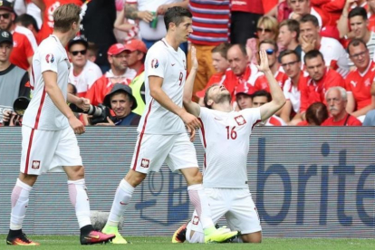 Blaszczykowski, arrodillado en el césped, celebra su gol a Suiza junto a Lewandowski.-Laurent Cipriani