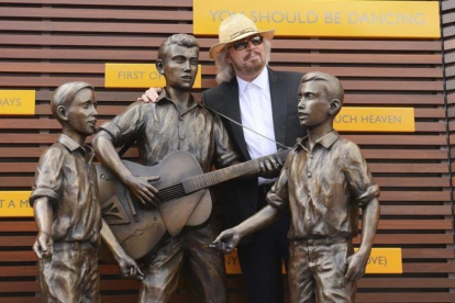 Barry Gibb posa junto a una estatua en honor de Barry  Robin y Maurice Gibbs  componentes del grupo Bee Gees en la inauguracion oficial del Paseo de lo Bee Gees en en Redcliffe, norte de Brisbane (Australia), en febrero del 2013.-