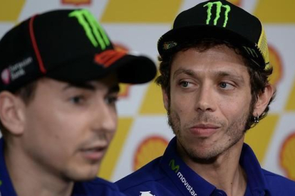 El piloto italiano Valentino Rossi escuchando las declaraciones de su compañero de equipo Jorge Lorenzo.-AFP / MANAN VATSYAYANA