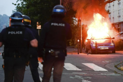 Varios policías ante un coche ardiendo, en Nantes.-/ AP / FRANCK DUBRAY