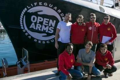 La tripulación integrada por miembros de la oenegé Open Arms junto al barco 'Golfo Azzurro' en el Port Vell de Barcelona.-JOAN CORTADELLAS