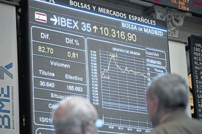 Dos inversores observan una pantalla con la evolución del Ibex 35 en la Bolsa de Madrid.-ARCHIVO / EFE