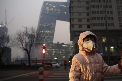 Una niña con una máscara protectora para la contaminación en Pekín, este lunes.-EFE