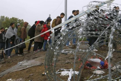 Refugiados cruzando la frontera entre Hungría y Croacia después de llegar en tren a la ciudad croata de Botovo.-LASZLO BALOGH / REUTERS
