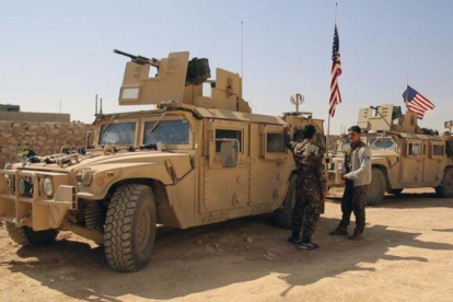 Combatientes de las Fuerzas Democráticas Sirias junto a vehículos militares de EEUU en las afueras de Manbij, en la provincia de Alepo, el 7 de marzo.-AP