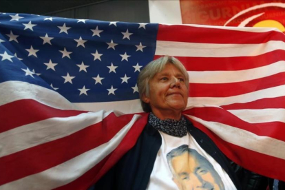 Una votante del DPS, del primer ministro de Montenegro, el prooccidental Milo Djukanovic, con una bandera de EEUU tras conocerse los resultados de las elecciones.-AP / DARKO VOJINOVIC