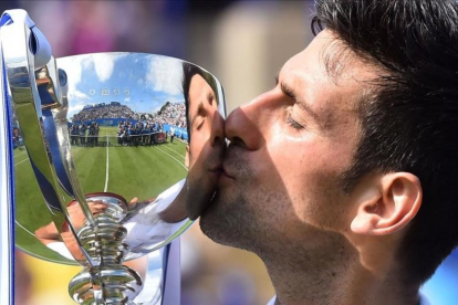 Novak Djokovic besa el trofeo del torneo de Eastbourne tras derrotar a Gaël Monfils en la final.-GLYN KIRK