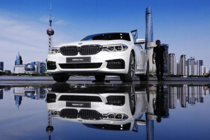 Un visitante observa el coche BMW 5-Series Li  en el salón de Shanghái.-SHERWIN (EFE)