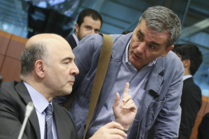 El comisario de Asuntos Económica, Pierre Moscovici (izqueirda), habla con el ministro griego de Finanzas, Euclides Tsakalotos, el martes en Bruselas.-EFE / OLIVIER HOSLET