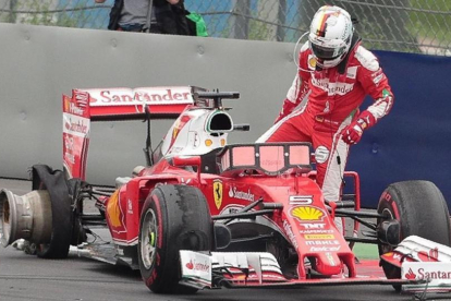 Sebastian Vettel se baja de su Ferrari tras estallar una de sus ruedas.-GEORG HOCHMUTH