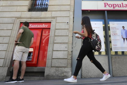 Oficina del Banco Santander junto a una del Popular en Madrid.-JUAN MANUEL PRATS
