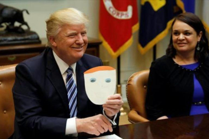 Trump muestra una tarjeta enviada por un niño, en la Casa Blanca.-REUTERS / KEVIN LAMARQUE