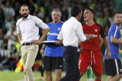 El jugador del Sevilla Roque Mesa (de rojo) protesta tras ser expulsado ante el Betis.-JOSE MANUEL VIDAL (EFE)