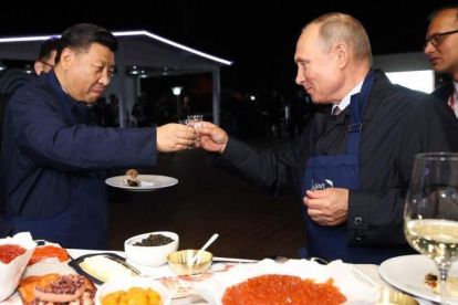 El presidente ruso, Vladimir Putin, brinda con su homólogo chino, Xi Jinping, en una feria alementaria en Vladivostok.-AFP / SERGEI BOBYLYOV