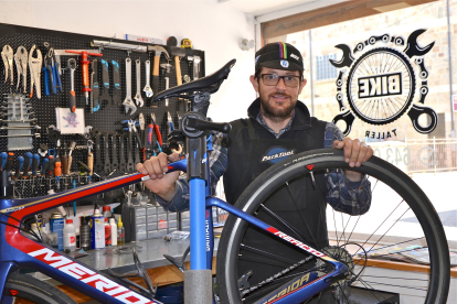 Israel Herrera junto a una bicicleta en el banco de trabajo. RAQUEL FERNÁNDEZ
