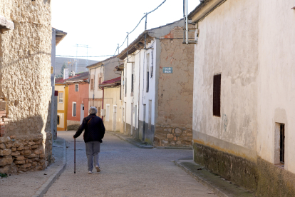 Una mujer camina por la calle de un pueblo de Valladolid.-ICAL