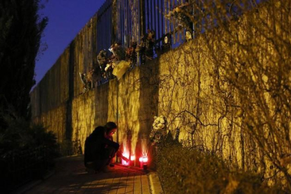 Una mujer enciende velas fuera de la estación de Atocha de Madrid en el undécimo aniversario del atentado del 11-M-REUTERS