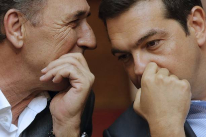 El primer ministro griego, Alexis Tsipras, habla con su titular de Economía, Giorgos Stathakis, este viernes en el Parlamento.-REUTERS / CHRISTIAN HARTMANN