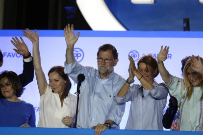 El presidente del gobierno en funciones Mariano Rajoy, acompañado por su mujer, Elvira Fernández (2i), Maria Dolores de Cospedal (2d), Cristina Cifuentes (d) y Soraya Sáenz de Santamaria, se dirige a los simpatizantes populares.-EFE