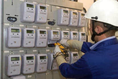 Un técnico revisa los contadores de electricidad hace unos días en Barcelona.-EL PERIÓDICO