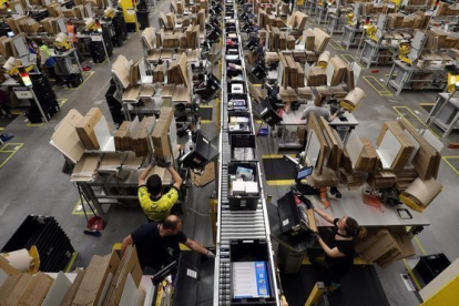 rabajadores empaquetan los pedidos de Amazon.-REUTERS