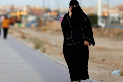 Una mujer saudi habla por teléfono mientras camina por una calle de Riad-REUTERS / FAISAL AL NASSER