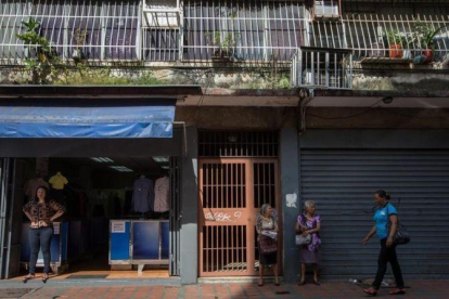 Un comercio abierto y otro cerrado en una calle de Caracas.-EFE / MIGUEL GUTIÉRREZ