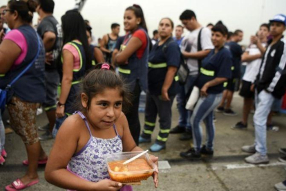 Una niña lleva su ración de comida servida durante una protesta social en Buenos Aires contra la pobreza, el 15 de marzo.-AFP / EITAN ABRAMOVICH