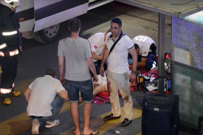 Víctimas, policías y personal sanitario, en el exterior del aeropuerto Atatürk de Estambul, después del atentado de anoche.-REUTERS / ISMAIL COSKUN