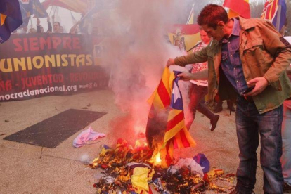 Varios manifestantes de la marcha ultra del 12-O en Barcelona queman una 'estelada'.-JOAN CORTADELLAS