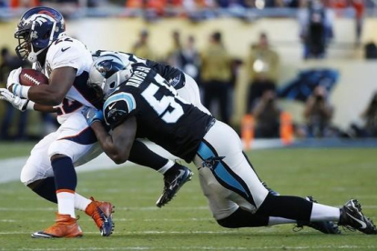El running back de los Broncos J. Anderson, interceptado por Thomas Davis de los Carolina Panthers.-