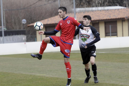 Elgezabal pugna por el balón con un jugador del Tudelano, ayer, en la Ciudad del Fútbol.-LUIS ÁNGEL TEJEDOR